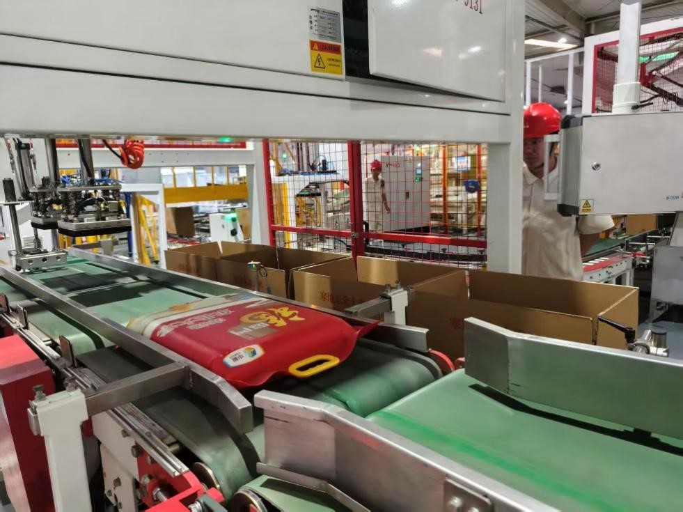 粮食生产线上，一袋袋大米被打包入箱。人民网记者 李栋摄